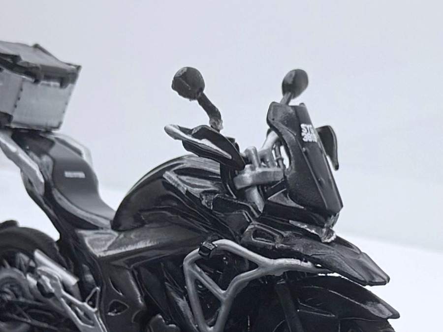 Close up on the handlebars, mirrors, levers and crash bars of the scale model motorcycle