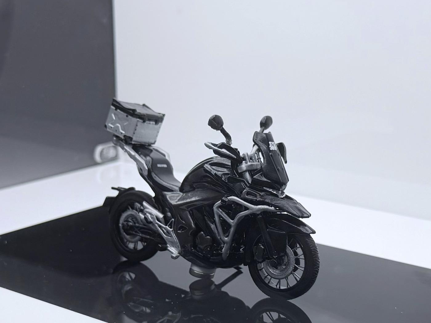 A 1:24 scale custom model motorcycle, front three-quarter, in a lit display case
