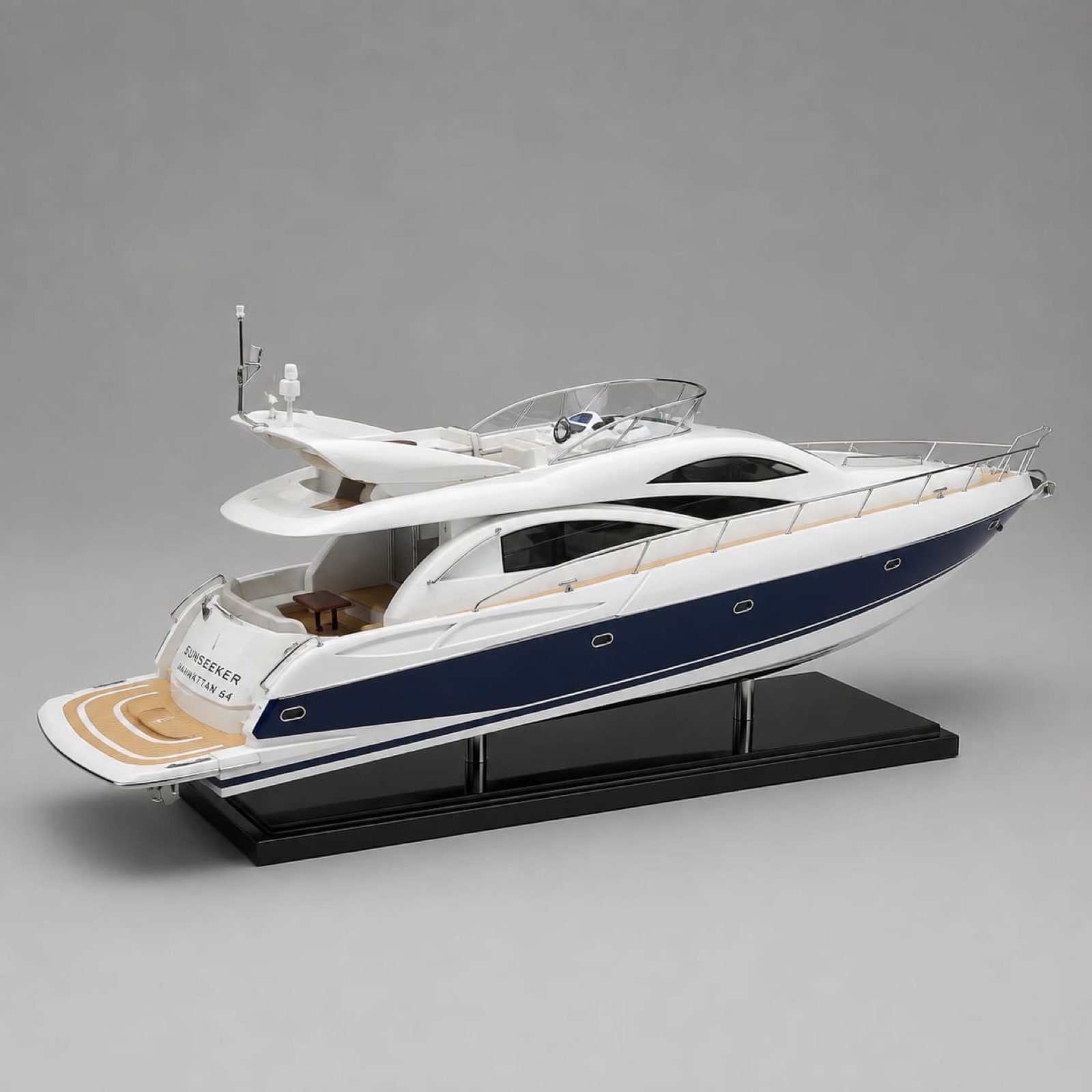 A Sunseeker Manhattan 64 yacht scale model with a navy hull on a black display stand