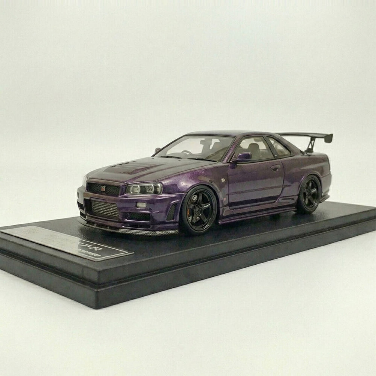 A hand-finished scale model of a purple Nissan Skyline GT-R R34 on an engraved plinth